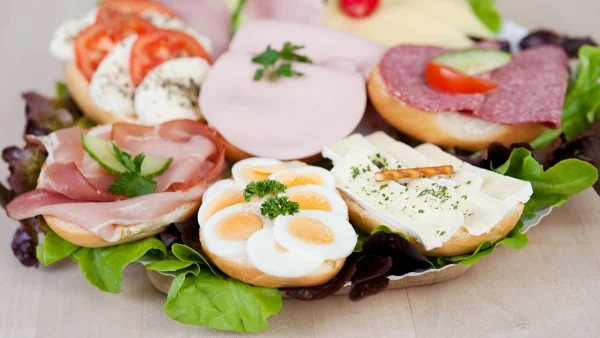Hanke Catering Platte mit belegten Brötchen, Wurst, Käse, Ei, Tomaten und frischem Salat.