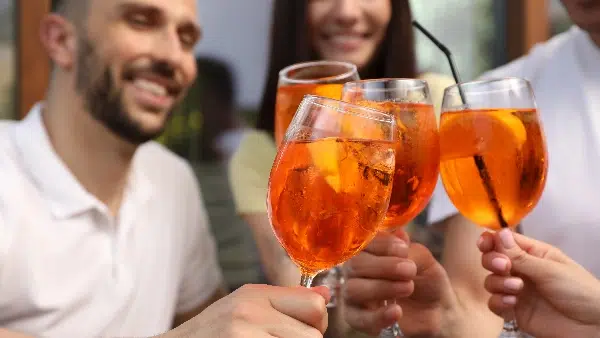 Zwei Gäste stoßen mit Aperitif-Gläsern an – Aperitif-Empfang als stimmungsvoller Auftakt beim Full Service Catering.