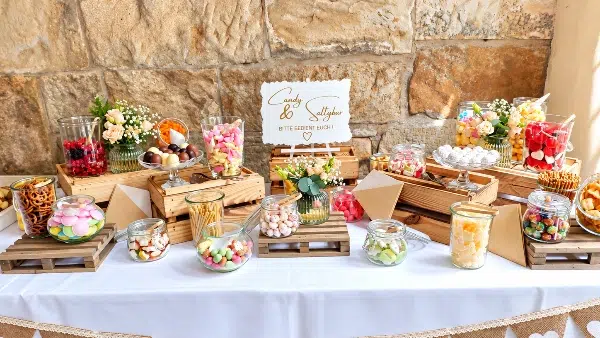 Candybar mit Cupcakes, Süßigkeiten und Naschereien vor Natursteinwand – süßes Extra beim Full Service Catering für Hochzeiten und Feiern.